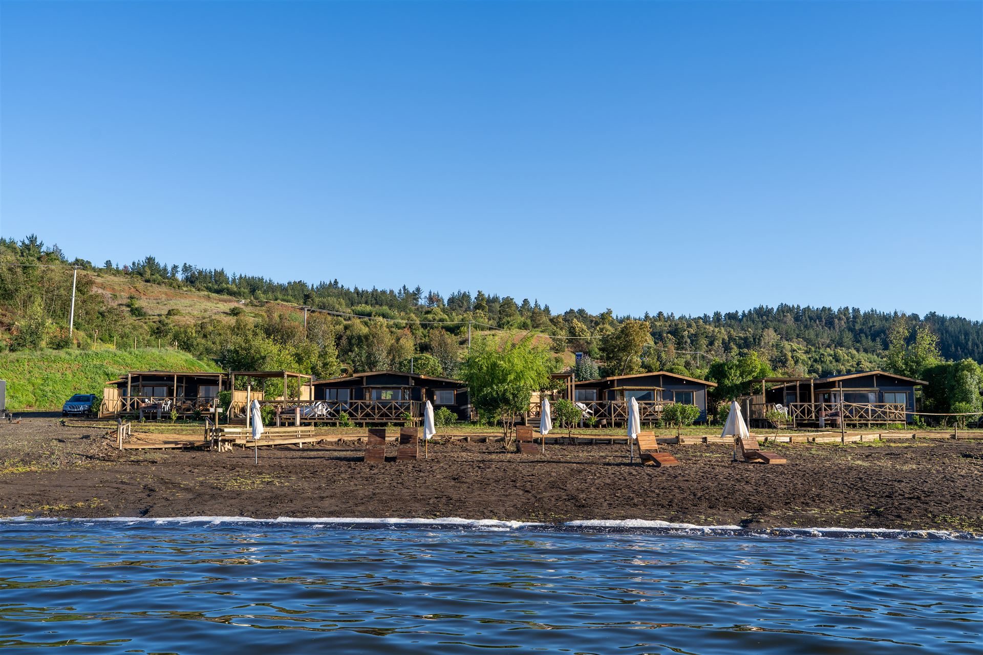 Las cabañas y la costanera del recinto vistas desde el lago